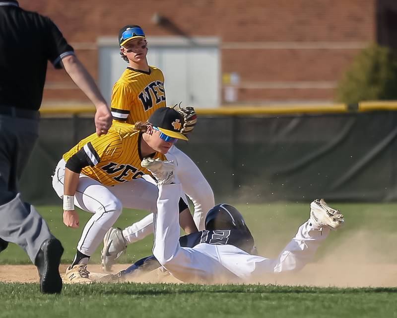 Joliet West's Owen Young (33) tags the runner out at second for the out during varsity baseball game between Oswego East at Joliet West.  April 10, 2023.