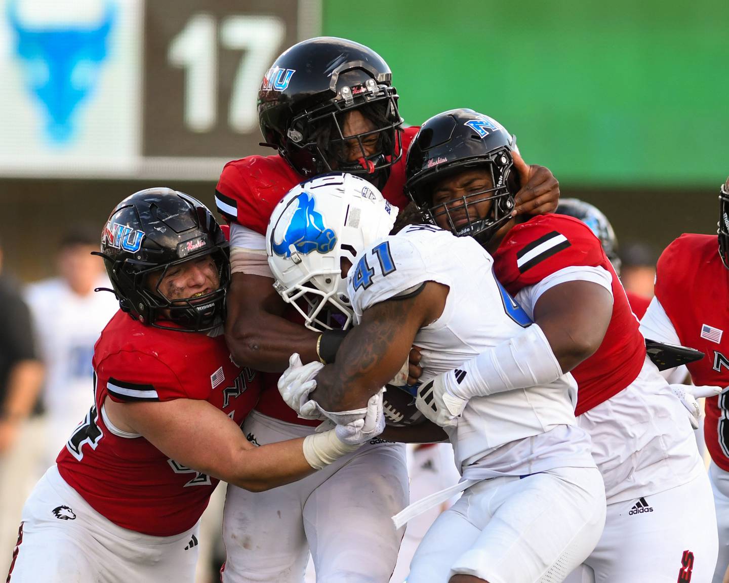 A group of Northern Illinois football players hold back Al-Jay Henerson (41) from gaining yards late in the game on Saturday Sept. 21, 2024, held at Huskie Stadium in DeKalb.