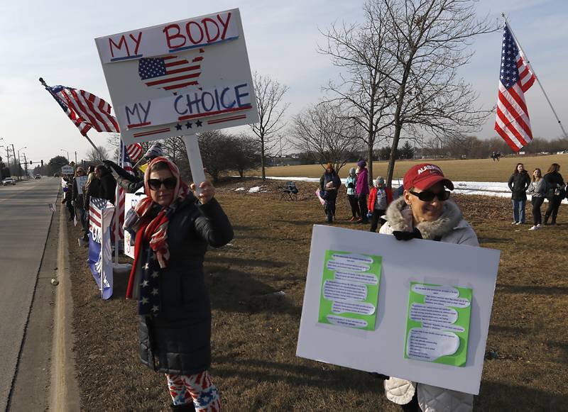 Bonnie Cassel and Maribeth Barkocy, both of Crystal Lake, protest during a Cary School District 26 anti-mask rally Tuesday, Feb. 15, 2022, along Three Oaks Road at Cary-Grove Park. The event was attend by about 100 people and organized by the Illinois Parents Union Cary.