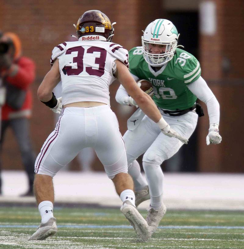 York’s Anthony Mancini Jr. (38) tries to move past Loyola's Johnny McGuire (33) during the IHSA Class 8A semifinal football game Saturday November 19, 2022 in Elmhurst.