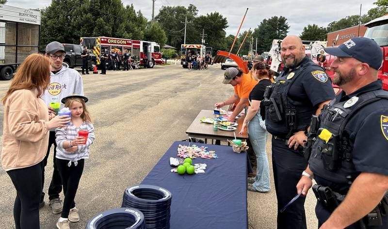 Oregon Interim Police Chief Matt Kalnins and School Resource Officer Tim Brechon greet visitors to National Night Out, held in conjunction with the Oregon Park District at River's Edge Experience in Oregon on Tuesday, Aug. 6, 2024.