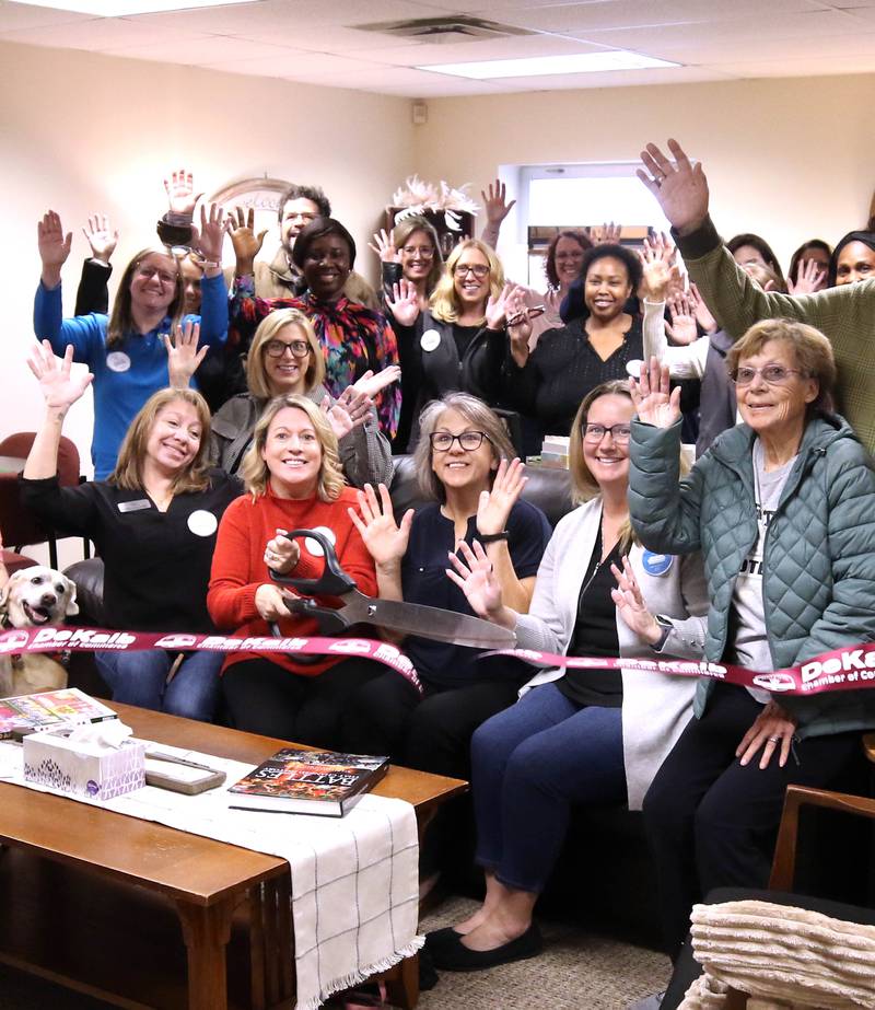 Tara Russo, executive director of Elder Care Services, cuts the ribbon Wednesday, Nov. 20, 2024, with other members of the staff and attendees at Elder Care Services’ new Cozy Corner in their facility at 1701 East Lincoln Highway in DeKalb. Cozy Corner offers seniors a community space for socializing, learning and activities.