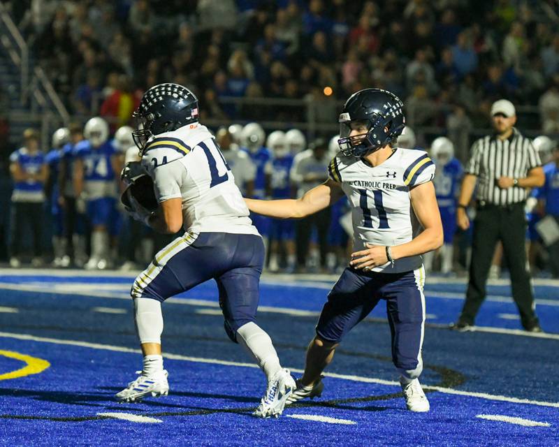 IC Catholic Prep Dennis Mandala, right, hands the ball off to teammate David Velez during the second quarter on Friday Sep. 29, 2023, while traveling to take on St. Francis in Wheaton.
