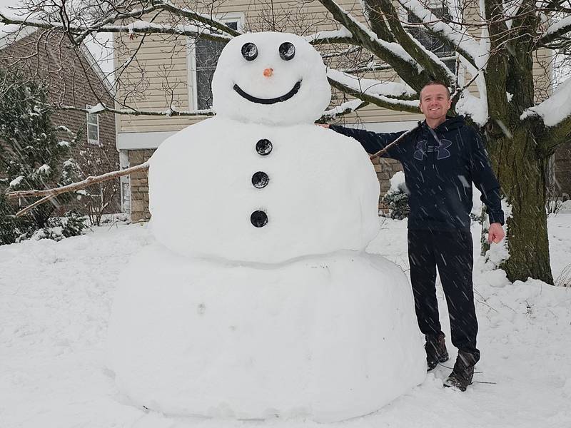 Josh Barnard, 33, of McHenry, poses with an approximately 7-foot snowman he sculpted on Friday, Jan. 12, 2024.