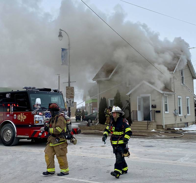 DeKalb firefighters walk toward a two-story duplex to help the emergency response on Saturday, Jan. 24, 2026, at Seventh Street and East Lincoln Highway downtown.