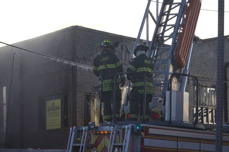 Joliet firefighters at the scene of a fire at an old commercial building on Thursday, Jan. 29, 2026, at the corner of South Eastern Avenue and Washington Street in Joliet.