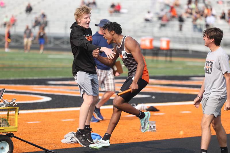 Minooka’s DJ Smith, right, celebrate finishing first place in the 4x100 Meter Relay at the Class 3A Minooka Boys Track and Field Sectional on Wednesday, May 17, 2023 in Minooka.