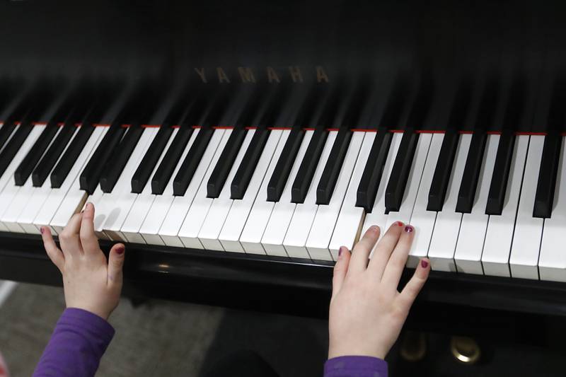 Claire Koll, 8, of Crystal Lake, plays the piano during a lesson Tuesday, Feb. 22, 2022, at Encore Music Academy, 87 N. Williams St., in Crystal Lake. The academy moved into its new location over Thanksgiving week last year. The larger location allows for the expansion of its private student instruction and also has a large space suitable for performing.