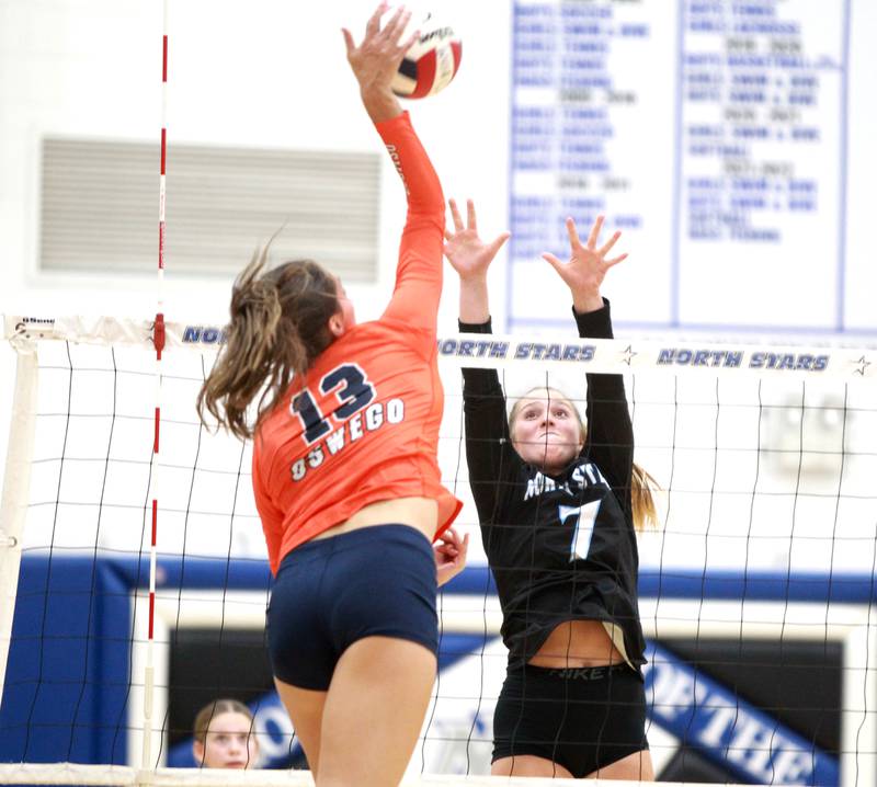 St. Charles North's Mia McCall (7) goes up for a block against Oswego’s Sidney Hamaker (13) during a game Wednesday, Sept. 18, 2024 at St. Charles North.