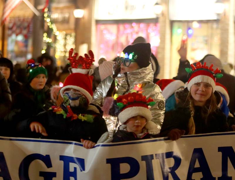 Youngsters march with a group from Sage YMCA Piranhas during the Festival of Lights Holiday Parade in downtown Crystal Lake on Friday, Nov. 29, 2024.