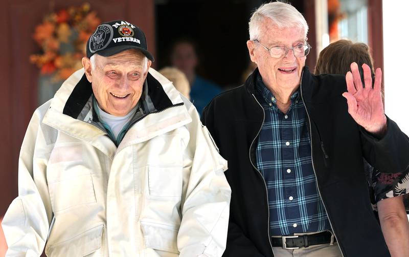 US Navy veteran Richard Korleski, (left) 93, and Ken Cooper, 96, a US Army veteran, wave to members of the Kunkel family as they pass by in a small parade on Veterans Day,  Friday, Nov. 11, 2022, at the Grand Victorian assisted living facility in Sycamore. Sycamore resident Joann Kunkel read a story in the current Midweek that contained a quote from one of the veterans at the facility that lamented the lack of a parade. So she and her grandkids decided to have one for them.
