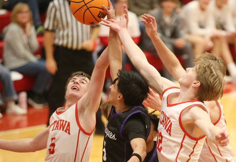 Ottawa's Kylar Araujo and teammate Aric Threadgill jump for a rebound with Plano's Alan Conteras during the Dean Riley Shootin' The Rock Thanksgiving Tournament on Tuesday, Nov. 26, 2024 in Kingman Gym at Ottawa High School.