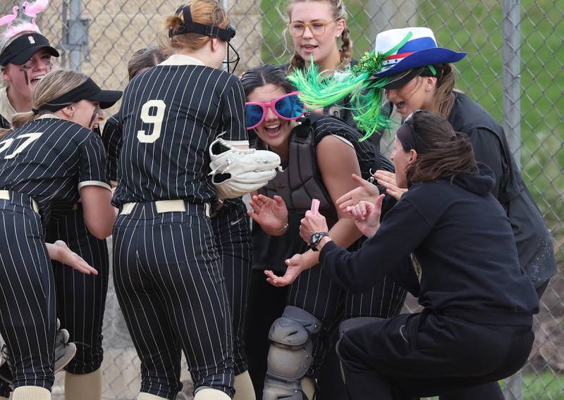 Sycamore players stay loose before the game as they greet head coach Jill Carpenter in the pregame huddle Tuesday, April 22, 2025, before their game against Kaneland at Sycamore High School.