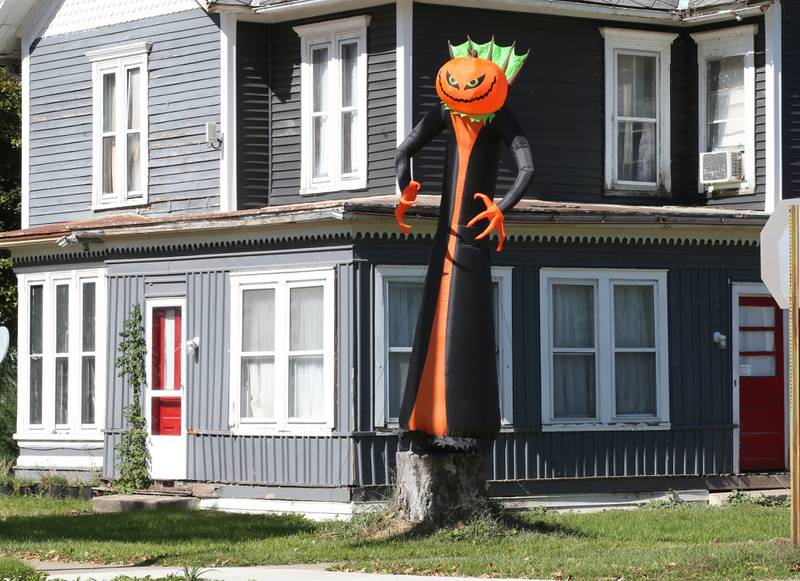 This tall inflatable very tall scary pumpkin stands on top a stump at the intersection of North 3rd Street and East High Streets on Tuesday, Oct. 10, 2023 in Hennepin.