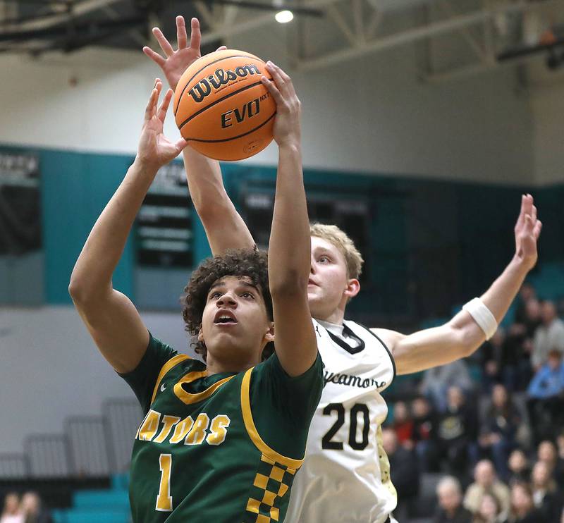 Crystal Lake South's Noah Cook drives to the basket in front of Sycamore's Isaiah Feuerbach during an IHSA Class 3A Woodstock North Sectional semifinal.basketball game on Wednesday, March 4, 2025, at Woodstock North High School.
