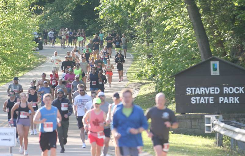 Hundreds of runners pass by the entrance to Starved Rock State Park while competing in the Starved Rock Country half-marathon on Saturday, May 10, 2025 at Starved Rock State Park.