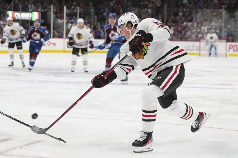 Chicago Blackhawks right wing MacKenzie Entwistle shoots against the Colorado Avalanche during the second period of an NHL hockey game in Denver. (AP Photo/Jack Dempsey)