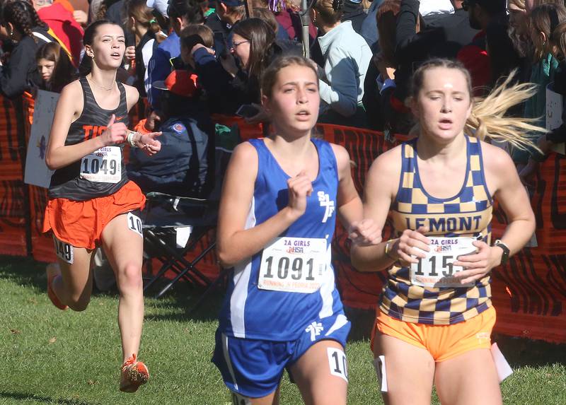 Crystal Lake Central's Jacqueline Orvis, Wheaton St. Francis's Addy Wordekemper and Lemont's Cassie Cunningham compete in the Class 2A State Cross Country race on Saturday, Nov. 4, 2023 at Detweiller Park in Peoria.