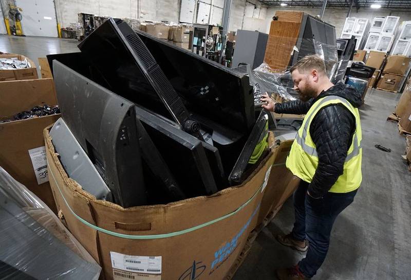 Elgin Recycling marketing manager Brett Barton looks over some of the televisions collected at the company's four public electronics drop-off sites. The company operates facilities Monday through Saturday in Crystal Lake, Elgin, Arlington Heights and Gilberts.