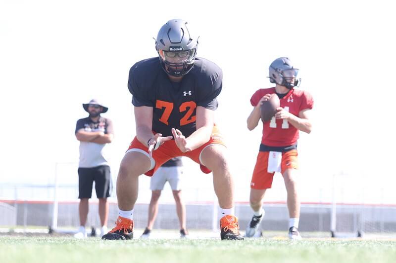 Minooka Center Ryan Susnar, 72, works on snaps with quarterback Gavin Dooley during practice. Wednesday, Aug. 10, 2022, in Minooka.