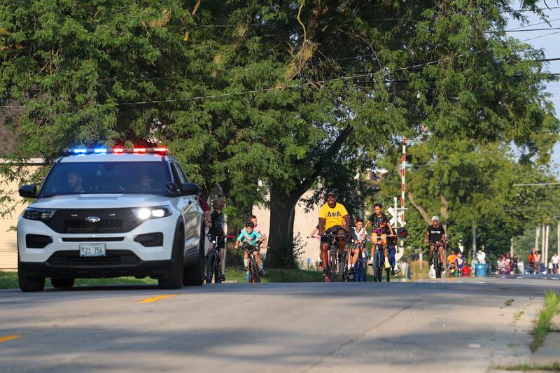 Kankakee Police Deputy Chief Donell Austin, center, helps lead the pack along East Chestnut Street in Kankakee during the annual Bike Against Violence ride on Tuesday, July 22, 2025.
