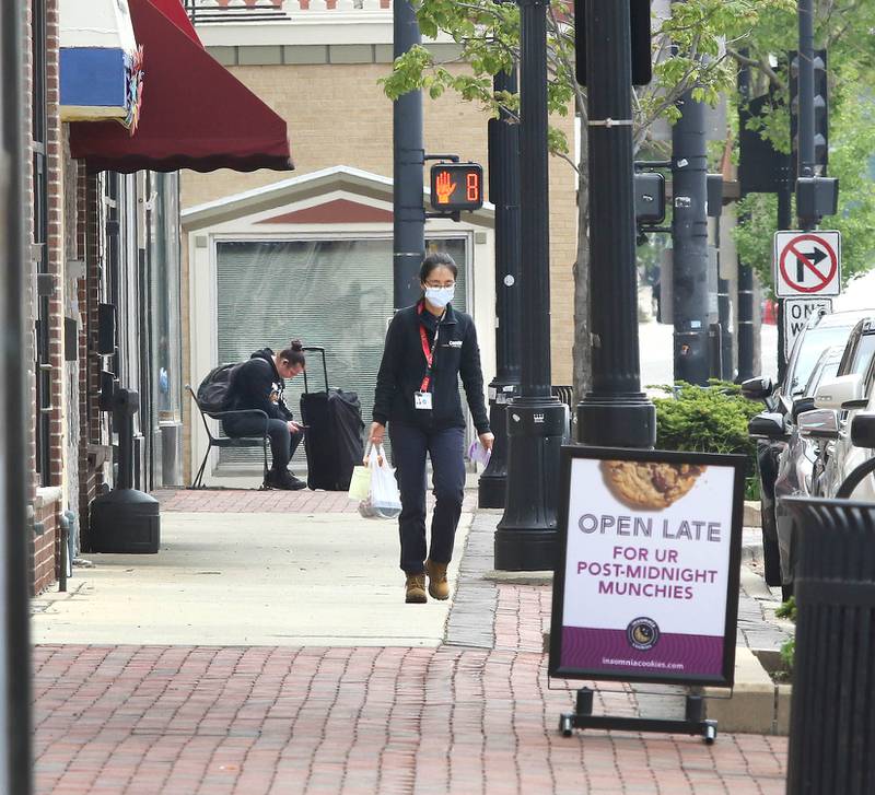 A shopper walks down the sidewalk on Lincoln Highway between Second and Third Streets Tuesday, May 24, 2022, in DeKalb. Road construction will be starting soon on the section of Lincoln Highway between First and Fourth Streets which will afford some businesses more sidewalk space in front of their stores.