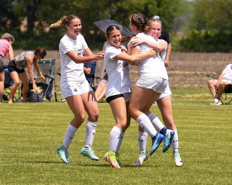 Sycamore's Grace Amptmann, left, Faith Schroeder, center, Sycamore's Cortni Kruizenga, right, all hug Sycamore's Anya Berry (7) after scoring the final penalty kick securing the regional title win over Kaneland on Saturday May 18, 2024, held at Kaneland High School.