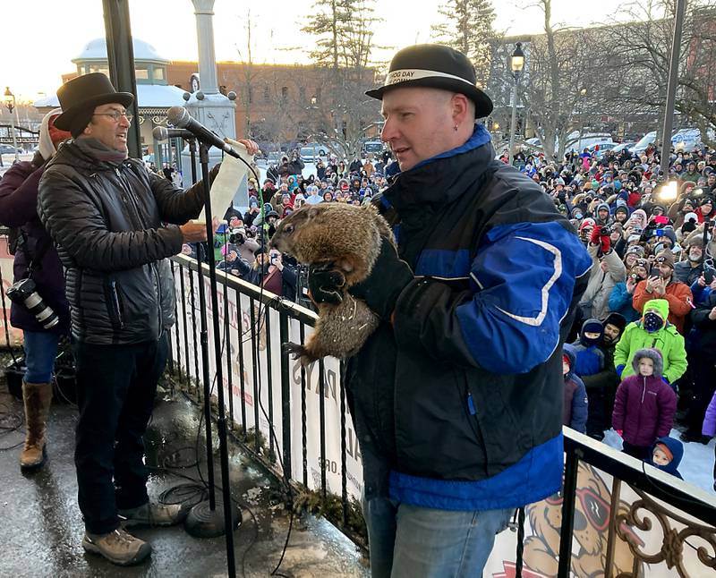 Woodstock Willie is held by handler Mark Szafran as Willie makes his prognostication of six more weeks of winter Thursday, Feb, 2, 2023, while Danny Rubin, the screenwriter of the "Groundhog Day" movie that was filmed in Woodstock, announces Willie’s findings during the annual Groundhog Day Prognostication on the Woodstock Square.