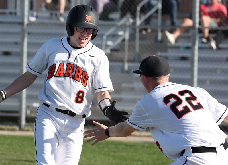 DeKalb's Connor McPartlin (left) is greeted by DeKalb’s Ryan Mays after scoring a run during their game against Naperville Central Tuesday, April 30, 2024, at DeKalb High School.