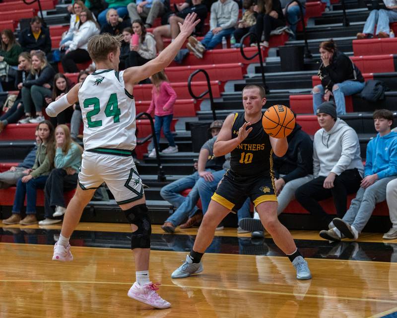 Traxton Mattingly (10) of Putnam County looks to pass ball as Owen Mandrell (24) of Rock Falls guards him during the Calmone Classic on Monday, December 8, 2025 at Hall High School in Spring Valley.