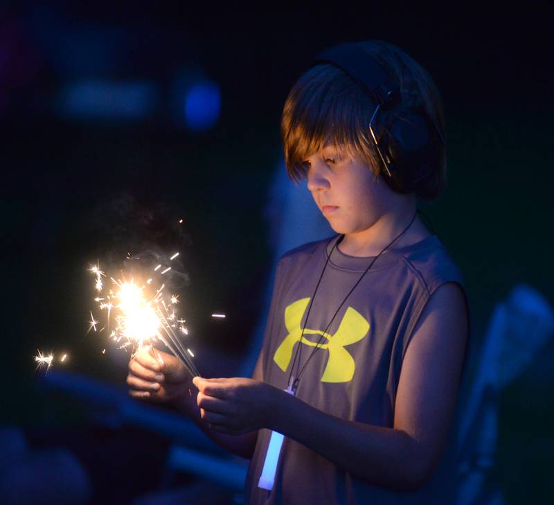 Victor Adams, 9, of Prophetstown, plays with a sparkler as he waits for the fireworks to begin at Prophetstown State Park on Saturday, July 6, 2024.