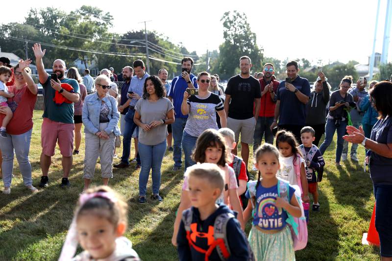 Parents watch as students enter the school on the first day Thursday, Aug. 22, 2024 at Harrison Street Elementary School in Geneva.
