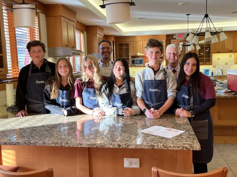 Pictured (l to r): Franklin Barnes '27 (Clarendon Hills), Chloe Rothermel '27 (Lombard), Gianna Bocconcelli '26 (Downers Grove), Principal Chris Tiritilli, Gabriella Oliverio '26 (Burr Ridge), Ethan Clapsaddle '26 (Addison), Campus Minister Michael Blanchette and Madalyn Aguilar '26 (Naperville) at the Ronald McDonald House in Winfield