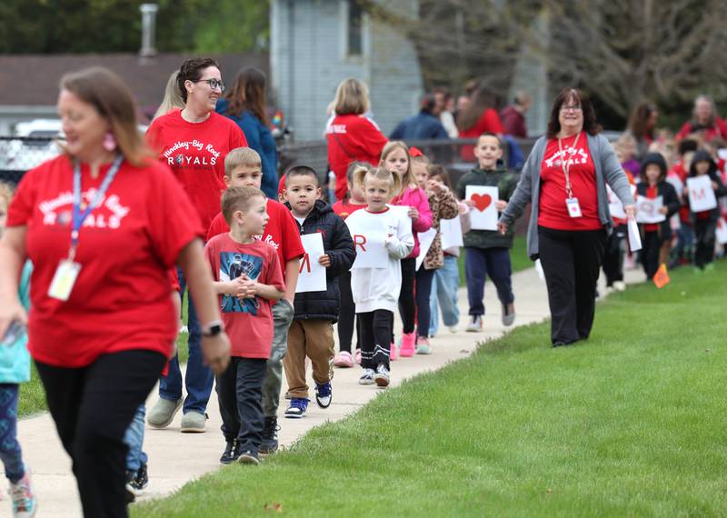 Hundreds of students from Hinckley-Big Rock Elementary School line up Monday, May 5, 2025, outside of the school as they await the arrival of Marshall Morong, 7, a first grader, for his first day back following months waiting for, and eventually receiving, heart transplant surgery at Lurie Children’s Hospital of Chicago. Morong arrived in style in a Tesla Cybertruck donated for use by Telsa of Naperville, along with an escort by Hinckley and Big Rock first responders.