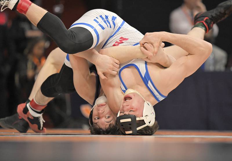 Hononegah’s Rocco Cassioppi, left, rolls Marmion’s Ashton Hobson in the Class 3A 150-pound match at the boys IHSA wrestling finals at State Farm Center in Champaign on Saturday, Feb. 21, 2026.