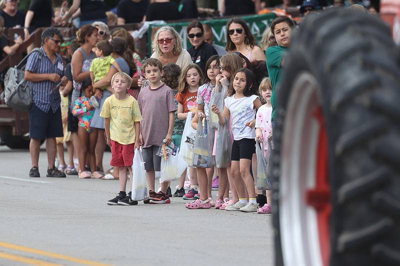 A group of kids watch as tractors ride along State Street in the Old Canal Days Parade on Friday June 7, 2024 in Lockport.