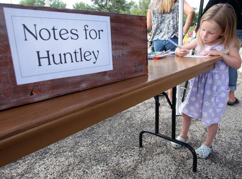 Avery Eagon, 5, of Fox Lake writes a note to Huntley during the final concert of the "It’s Thursday” summer concert series on August 10th in Antioch. Avery was at the event with her mother, Samantha. The event and its proceeds were dedicated to Huntley, a child who was injured during the Taste of Summer in July. 
Photo by Candace H. Johnson for Shaw Local News Network