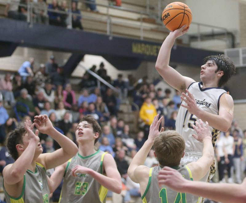 Marquette's Alec Novotney lets go of a shot over Seneca defenders on Friday, Feb. 21, 2025 in Bader Gym at Marquette Academy.