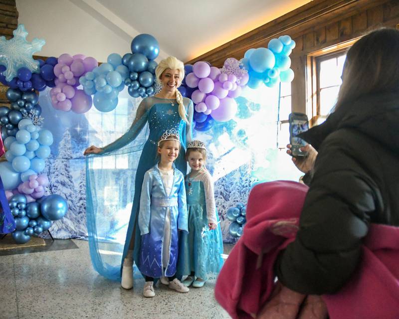 Emily Buh of Glen Ellyn takes a photo of her daughter, left, Sadie Buhr, 4, and niece Clare Neill,4, with Elsa from Frozen during the Frozen Fest event held at Lake Ellyn in Glen Ellyn on Saturday Jan. 20, 2024.