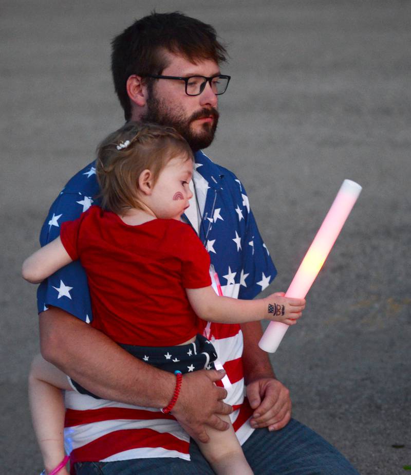 Brett Hines of Prophetstown carries his daughter Vivian, 3, to their blanket to watch the fireworks at Prophetstown State Park on Saturday, July 6, 2024.