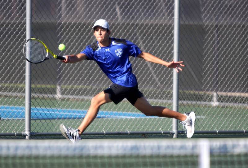 Geneva’s John D’Andrea reaches for the ball during a number one singles match against St. Charles North’s Mattas Ciabilis in St. Charles on Thursday, April 21, 2022.