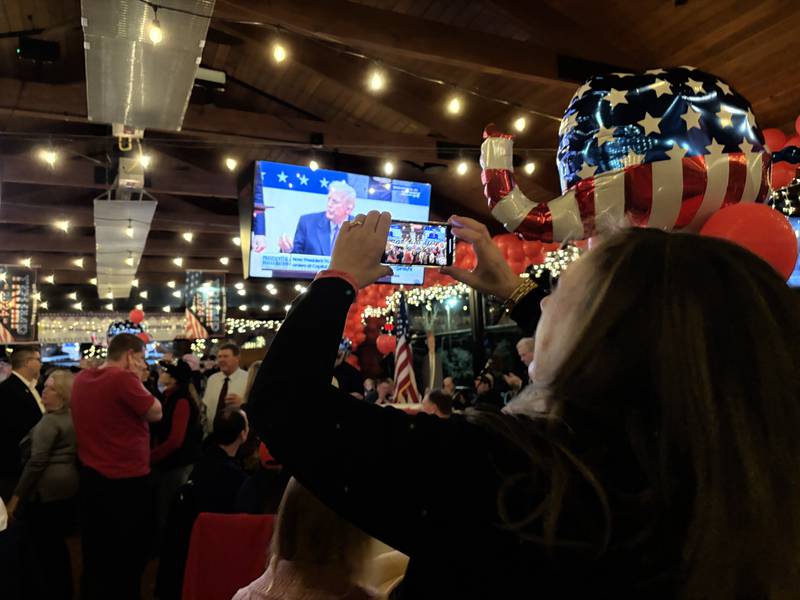 Gina Peshek, taking a photo, is among the McHenry County-area supporters of President Donald Trump celebrating the inauguration Monday, Jan. 20, 2025, at Niko’s Grill and Pub near Marengo