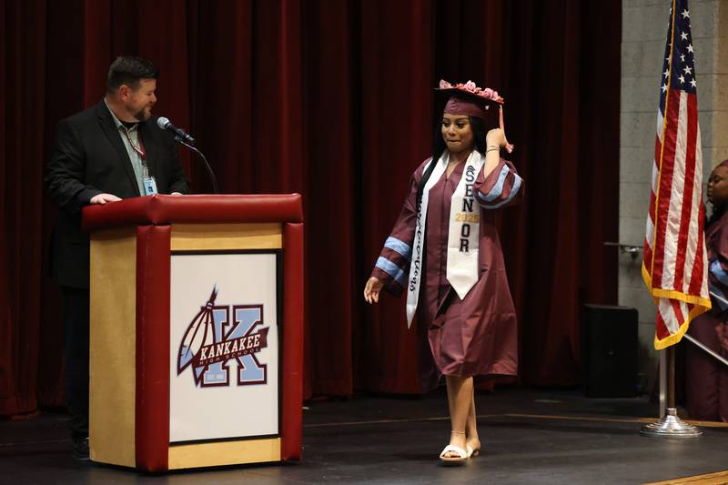 Kankakee High School graduate Trushay Sledge fixes her tassel as Assistant Principal Jason Worden, left, announced her name during the summer commencement ceremony at the high school on Tuesday, July 29, 2025.