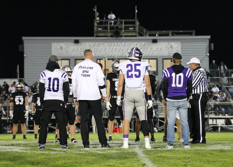 Rochelle and Kaneland players and coaches meet at midfield before Friday's game at Kaneland.