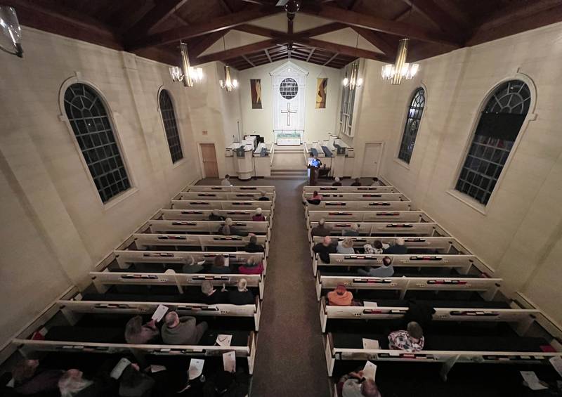 Attendees listen to a poem being read by Joe Gastiger Monday, Feb. 2, 2026, during the Vigil for Peace at the First Congregational United Church Of Christ in DeKalb. The vigil is being held in remembrance of those lost in recent ICE related shootings and to show solidarity with the people of Minnesota.