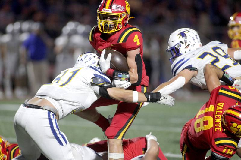 Batavia’s Charlie Whelpley carries the ball against Wheaton North’s Tony Garakat (left) during a game at Batavia on Friday, Sept. 22, 2023.