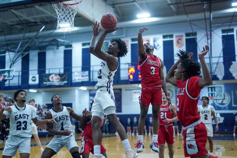 Oswego East's Jehvion Starwood (22) shoots the ball in the post against Yorkville's Dayvion Johnson (3) during a basketball game at Oswego East High School on Friday, Dec 8, 2023.