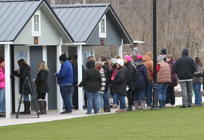 Dozens of wine enthusiasts collect tickets during the Winter Wine Walk on Saturday, Feb. 8, 2025 at the Market on Mill plaza in Utica.