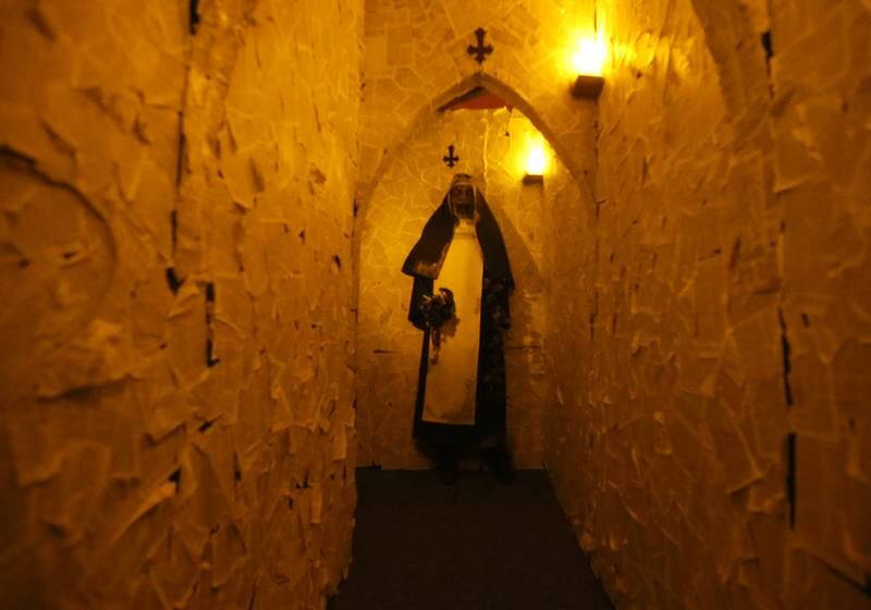 A nun figure greets visitors at the end of  a hallway of the Insanity Haunted House on Thursday, Oct. 3, 2024 at the Peru Mall. On the walls of the hallway are thousands of pages from the Bible.
