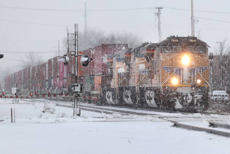 A train makes its way through the snow as it approaches the intersection of Lincoln Highway and Fourth Street Tuesday, Jan. 9, 2024, in DeKalb. Snow is expected to continue throughout the day with 7 to 10 inches of snow expected.